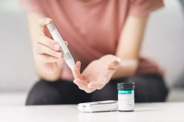 Woman using lancet on finger for checking blood sugar level by Glucose meter, Healthcare and Medical, diabetes, glycemia concept. Photo: iStock/Suriyawut Suriya